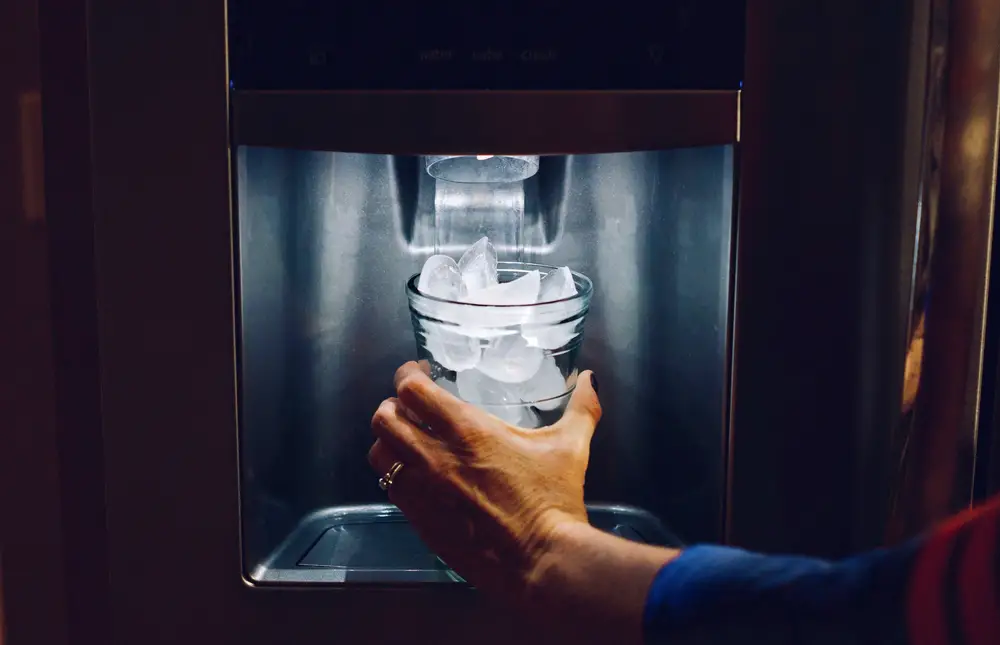 tall glass of ice in front ice machine